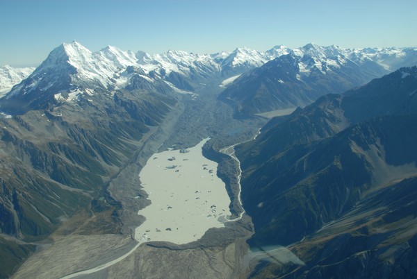 A massive lake of melted ice has formed at the foot of the Tasman glacier. The moraine wall is clearly visible to the left of the glacier. In 1900, people had to climb up from this wall onto the glacier. The Tasman Glacier is the largest glacier in New Ze